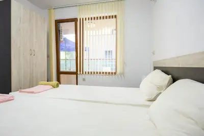 a bedroom with a large white bed with a window at Marea in Pomorie