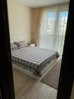 a bedroom with a bed and a large window at Cascadas one-bedroom apartment with a living room in Sunny Beach