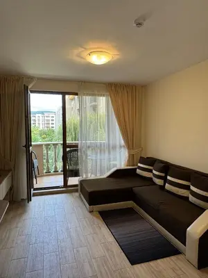 a bedroom with a couch and a large window at Cascadas one-bedroom apartment with a living room in Sunny Beach