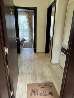an inviting hallway with a welcome mat on the floor at Апартамент Каскадас in Sunny Beach