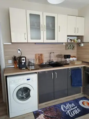 a kitchen with a washing machine and a sink at Comfort apartment near the beach in Varna City