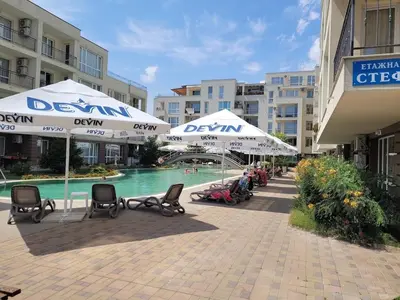 a resort with a pool and umbrellas and people sitting in chairs at Apartament Casa del Sol no 115 in Sunny Beach