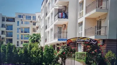 a tall white building with a sign in front of it at Apartament Casa del Sol no 115 in Sunny Beach