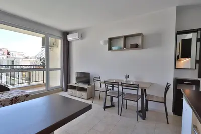a living room with a table and chairs and a window at Apartament Casa del Sol no 115 in Sunny Beach