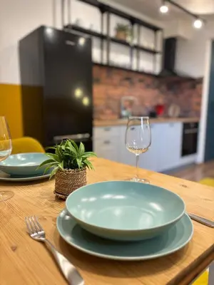 a wooden table with two plates and wine glasses at Cozy Corner in Varna - Free Parking in Varna City