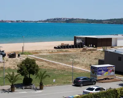 a car parked in front of a building next to a beach at 