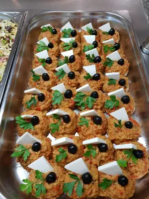 a glass baking dish filled with crackers with cheese and olives at Grenada Complex All Inclusive in Sunny Beach
