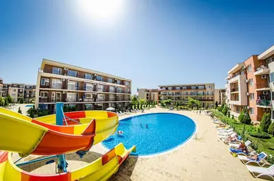 a resort with a pool and chairs and buildings at 2 Bed Suite with Pool Views in Sunny Beach