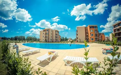 a swimming pool with lounge chairs and buildings at 2 Bed Suite with Pool Views in Sunny Beach