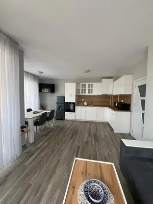 a large living room with a table and a kitchen at Апартамент Габи 1 in Burgas City