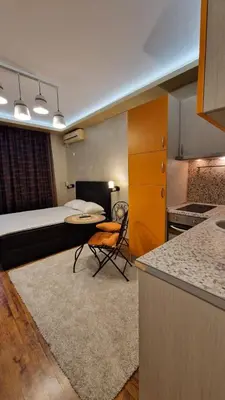 a room with a bed and a kitchen with a table at MitProt Panorama Bay 2 luks Studio 158 in Sveti Vlas