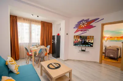 a living room with a blue couch and a table at Бургаски вечери Burgas nights in Burgas City