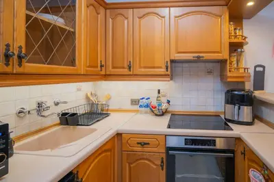 a kitchen with wooden cabinets and a sink at Бургаски вечери Burgas nights in Burgas City