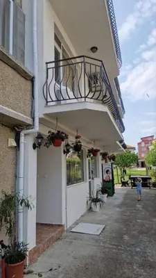 a balcony on the side of a building with plants at Къща за гости Ravda in Ravda