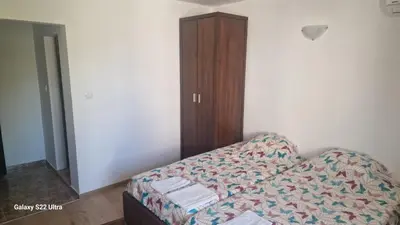 a living room with a couch and a wooden cabinet at Къща за гости Ravda in Ravda