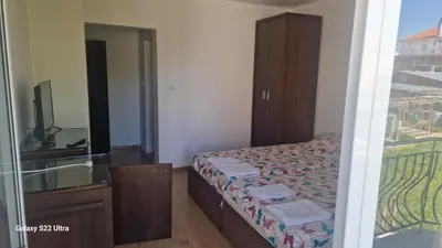 a bedroom with a bed and a sink and a mirror at Къща за гости Ravda in Ravda