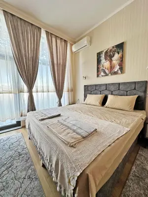 a bedroom with a large bed in front of a window at Villa Roma Gs' Apartment in Nesebar