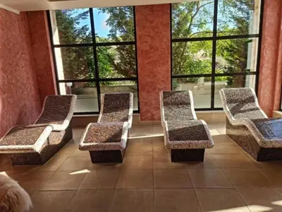 a waiting room with wicker chairs and windows at Villa Roma Gs' Apartment in Nesebar