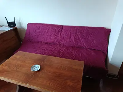 a purple couch with a wooden table in a room at Апартамента на центъра на Варна до фонтаните in Varna City