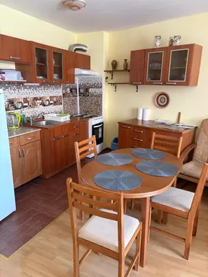 a kitchen with a table and chairs in a kitchen at Amartmán přímo u moře - Elenite in Sveti Vlas