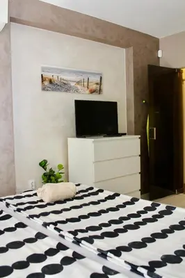 a bedroom with a bed with a black and white rug at Cozy by the Sea in Burgas City