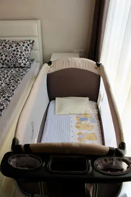 a baby crib with a mattress in a room at Cozy by the Sea in Burgas City