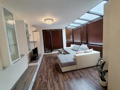 a living room with a white couch and a tv at Villa Alva in Pomorie
