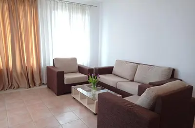 a living room with two couches and a coffee table at Апартаменти за гости Морска гледка in Chernomorets