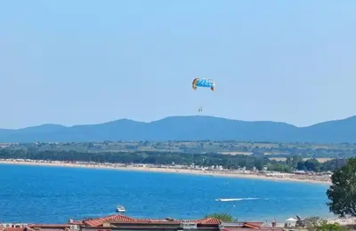 a view of a beach with a tower in the distance at Апартаменти за гости Морска гледка in Chernomorets