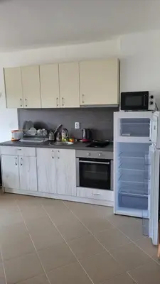 a kitchen with white cabinets and a stove top oven at Apartamenty na Zielonych Wzgórzach in Sunny Beach
