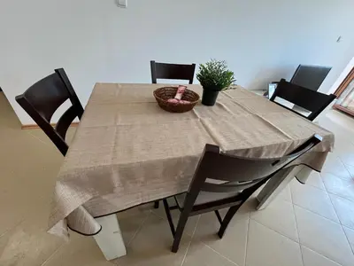 a dining room table with chairs and a plant on it at Apartamenty na Zielonych Wzgórzach in Sunny Beach
