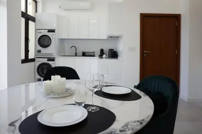 a dining room table with two white plates and wine glasses at Студио in Burgas City