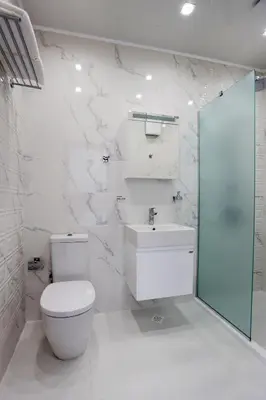 a white bathroom with a toilet and a sink at Студио in Burgas City