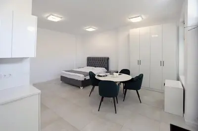 a room with a bed and a table and chairs at Студио in Burgas City