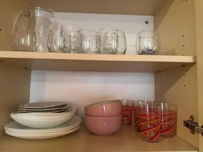a kitchen with plates and bowls and glasses on shelves at VP Royal Sun in Sunny Beach