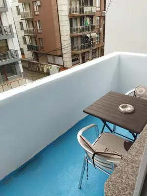 a table and a chair on a balcony at Emona 5 floor 3 in Burgas City