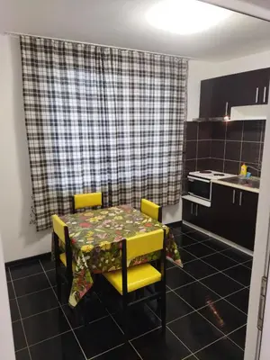 a kitchen with a table with yellow chairs and a table and a table at Emona 5 floor 3 in Burgas City