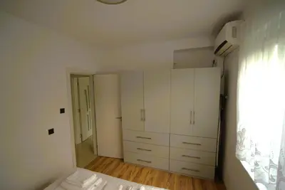 a white bedroom with white cabinets and a window at Emona 5 floor 2 in Burgas City