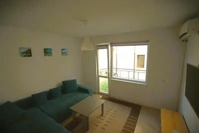a living room with a blue couch and a table at Emona 5 floor 2 in Burgas City