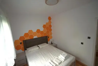 a bedroom with a bed with an orange wall at Emona 5 floor 2 in Burgas City