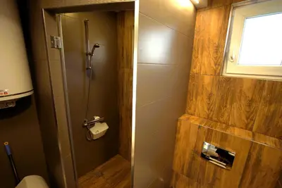 a bathroom with a shower with a toilet and a window at Emona 5 floor 2 in Burgas City