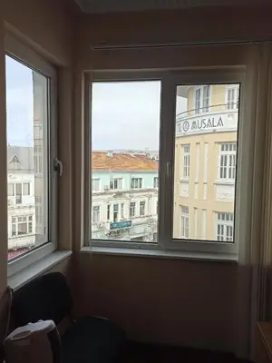 a window in a room with a view of a building at Апартамента на центъра на Варна до фонтаните и морето и градинта in Varna City