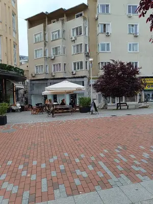 a building with a table and a white umbrella at Апартамента на центъра на Варна до фонтаните и морето и градинта in Varna City