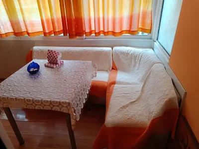 a small room with a table and a bed and a window at Апартамента на центъра на Варна до фонтаните и морето и градинта in Varna City
