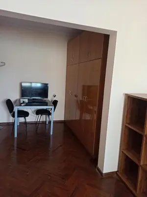 a room with a desk and a table and a cabinet at Апартамента на центъра на Варна до фонтаните и морето и градинта in Varna City