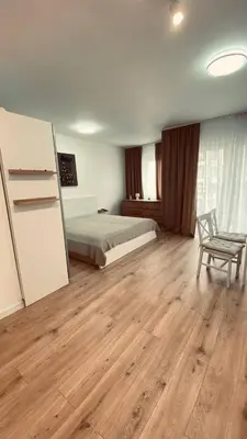a bedroom with a bed and a chair in it at Sveti Vlas, Rodopi Bay Apartment in Sveti Vlas