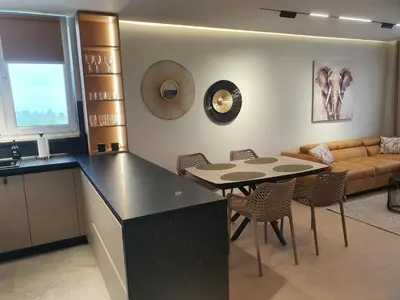 a kitchen and living room with a table and a couch at Divalla Apartment Burgas in Burgas City