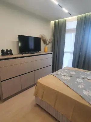 a bedroom with a bed and a flat screen tv at Divalla Apartment Burgas in Burgas City