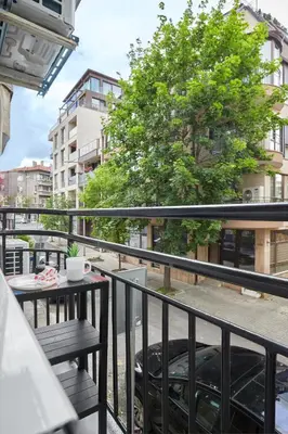 a balcony with a table and a tree at Sea Moreto Apartment 3 in Burgas City