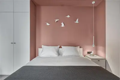 a bedroom with a bed with birds on the wall at Sea Moreto Apartment 3 in Burgas City